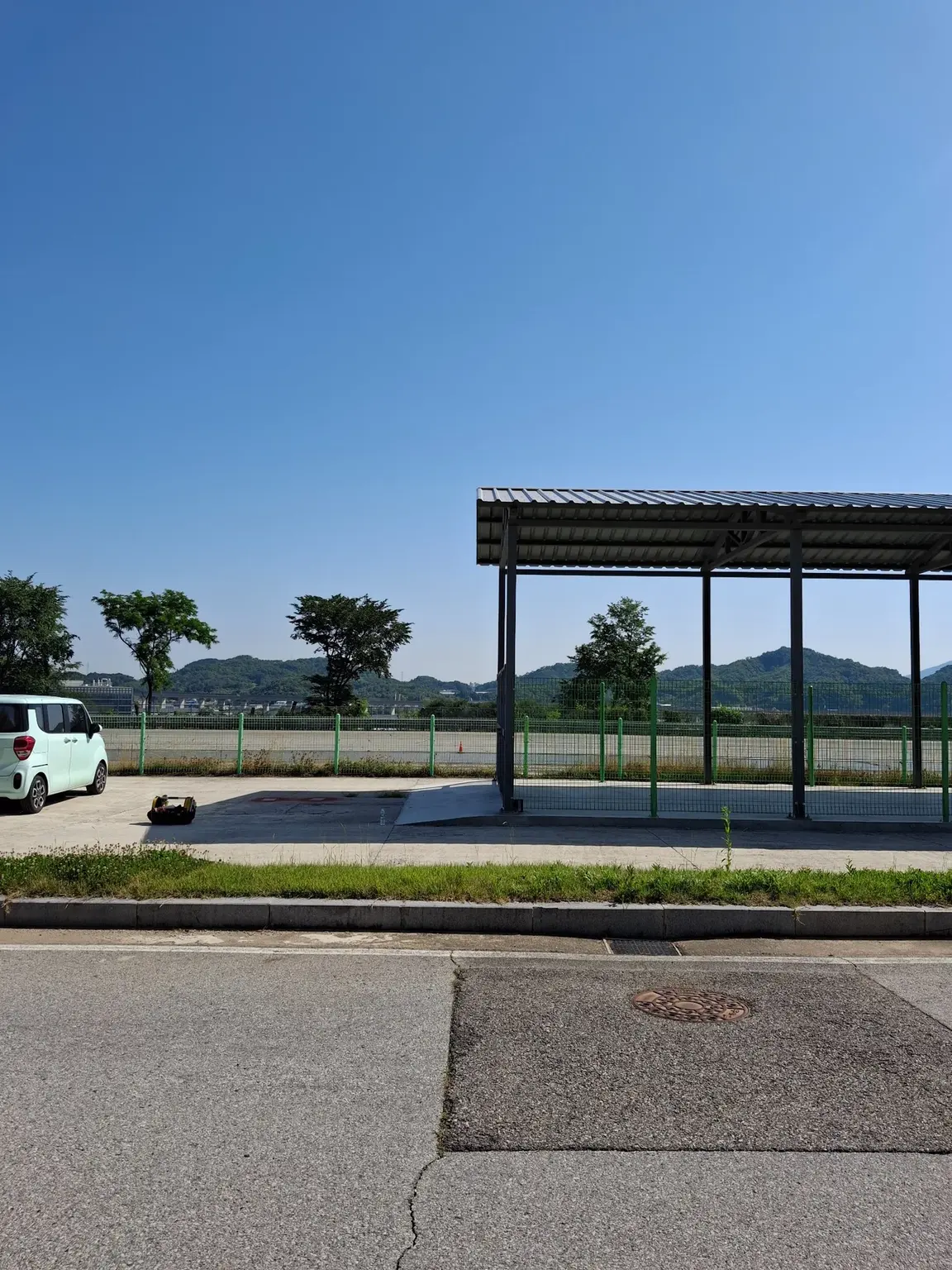 공장 외곽 도로와 작업장 앞 공간이 보이는 태양광가로등 설치 전 현장 확인